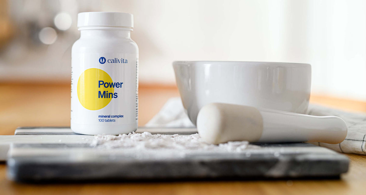 Suplement diety Calivita Power Mins, kompleks mineralny w białej butelce obok moździerza